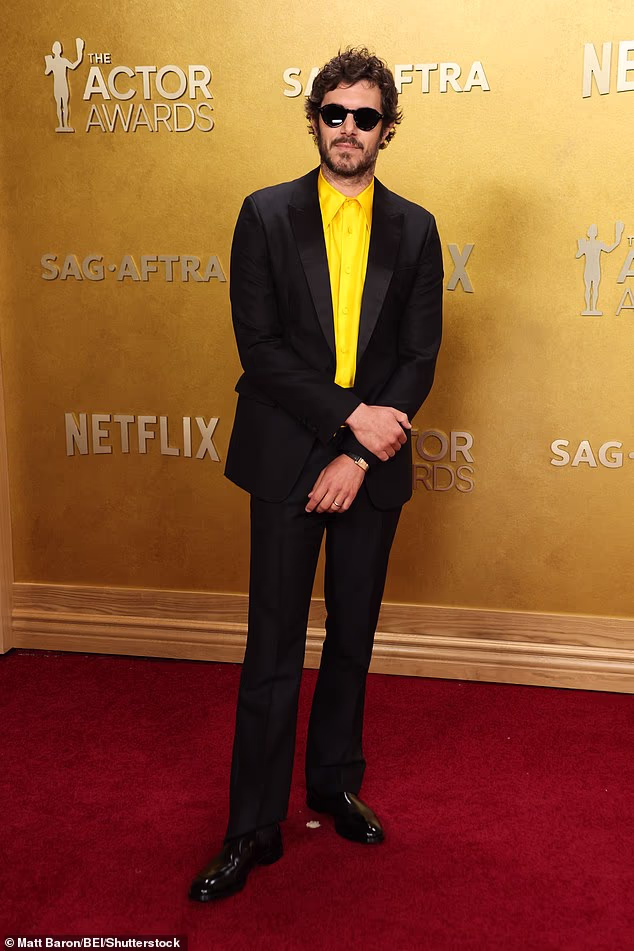 Adam Brody added a touch of color to his black suit with a bright yellow button up shirt
