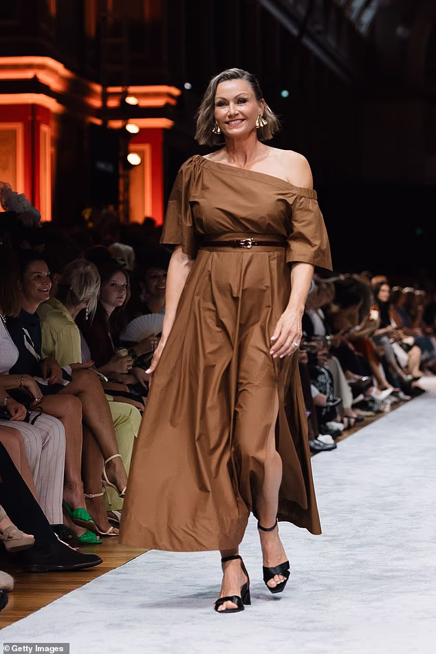 She also turned heads in a chic olive-toned dress that sat off one shoulder and flowed around her statuesque figure