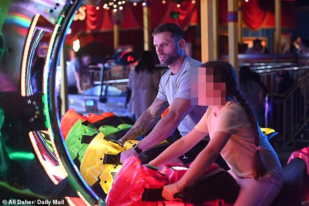 Scott sat beside Gia's daughter on a motorbike simulation game