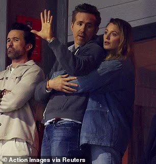 As Lively cheered on her husband's team from the stands, she was spotted wrapping her arms around his waist while standing close behind him