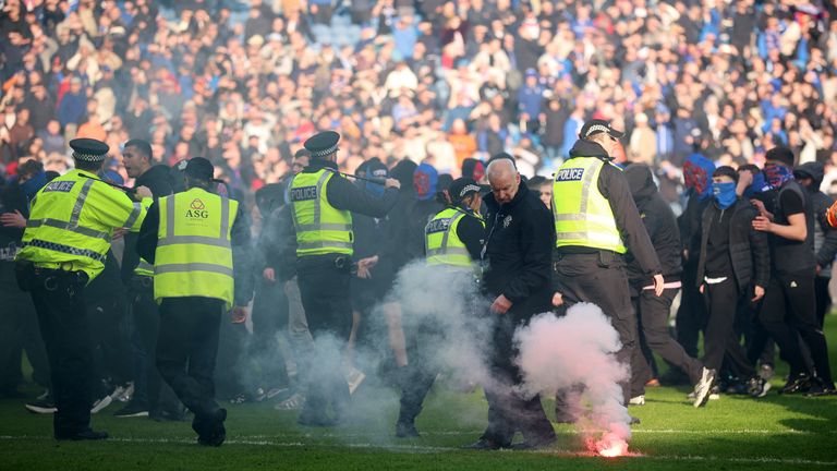 A flare on the pitch as police and stewards attempt to restore order. Pic: Reuters