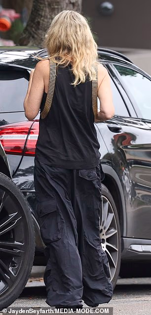 Henderson wore an all-black ensemble comprising baggy parachute pants teamed with a billowing tank top featuring gold detailing