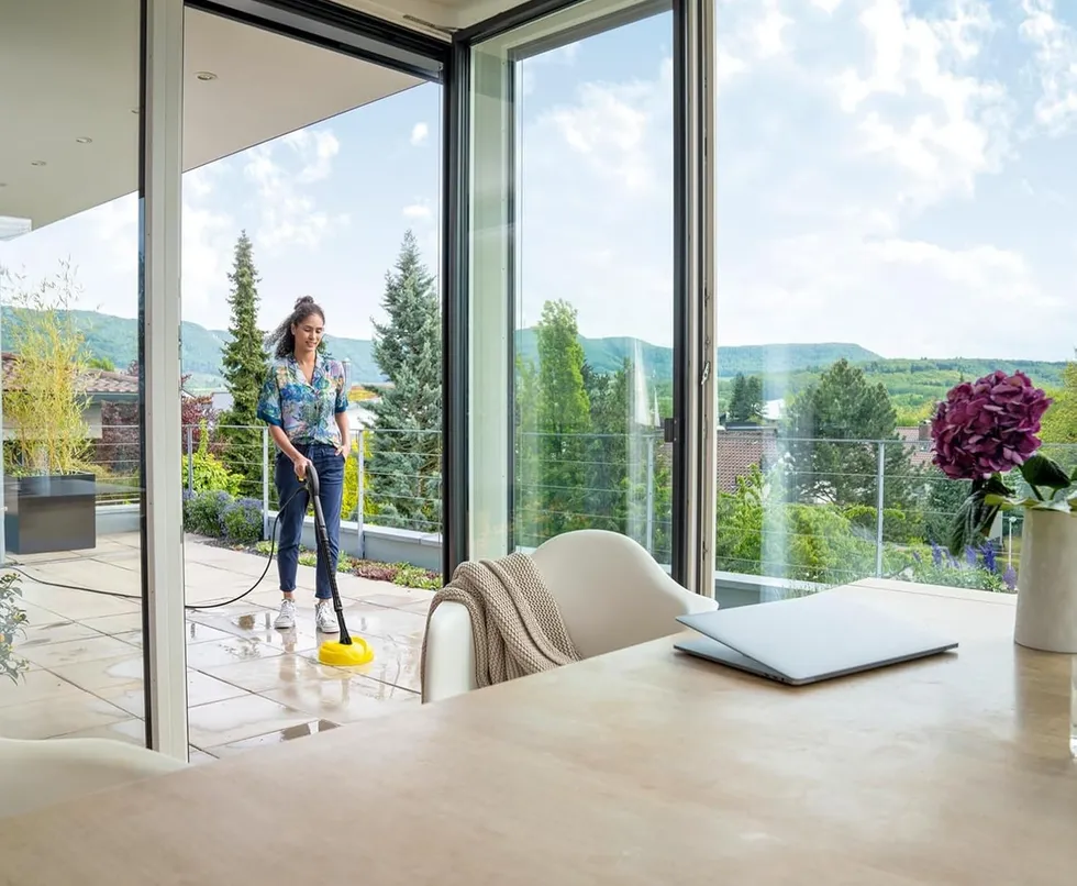 Woman cleaning outdoor area with the K\u00e4rcher K 2 Power Control Home pressure washer