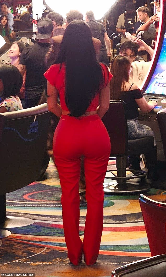 Kardashian's costume for the shoot consisted of an ab-flashing red crop top and skintight red lace-up pants that highlighted her famous hourglass curves