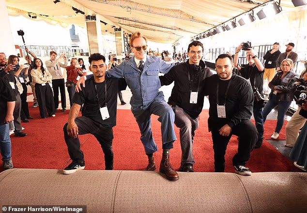 But the manual labor didn't last long as O'Brien began dramatically posing on the yet-to-be-unfurled carpet