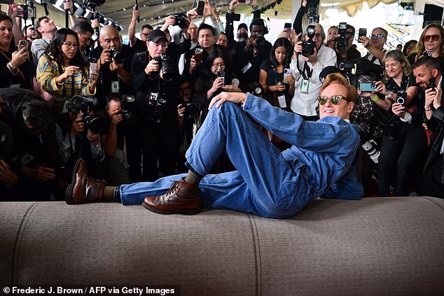 At one point, the Team Coco owner splayed his body lengthwise with one knee up while soaking up the attention