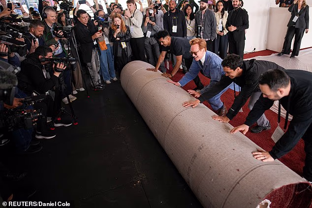 The six-time Emmy winner was joined by three crew members as they pushed the massive red carpet in unison for the snapping cameras inside the bustling Ovation Hollywood complex