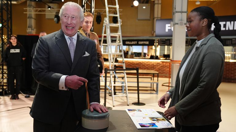 King Charles is gifted some cake during a visit to Aviva Studios. Pic: PA