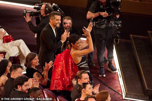 Taylor claimed the spotlight by leaping to her feet and wildly clapping the air as Madigan made her way to the stage - a stark contrast to the subdued response shared by her fellow nominees