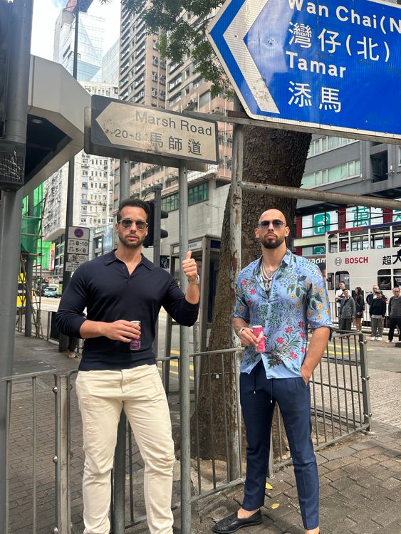 Tristan (L) and Andrew Tate posed in Hong Kong below a road sign with the same name as where they grew up in Luton. Pic: Andrew Tate @Cobrat