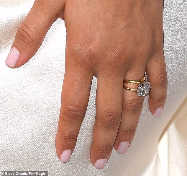 Speaking of wedding bling, the Louis Vuitton brand ambassador was wearing a simple gold band on her left-ring finger beside the $500K Jessica McCormack-designed engagement ring she debuted in January 2025