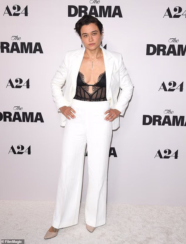 The Running Man action star Katy O'Brian wore a flirty black teddy beneath her sleek white pantsuit