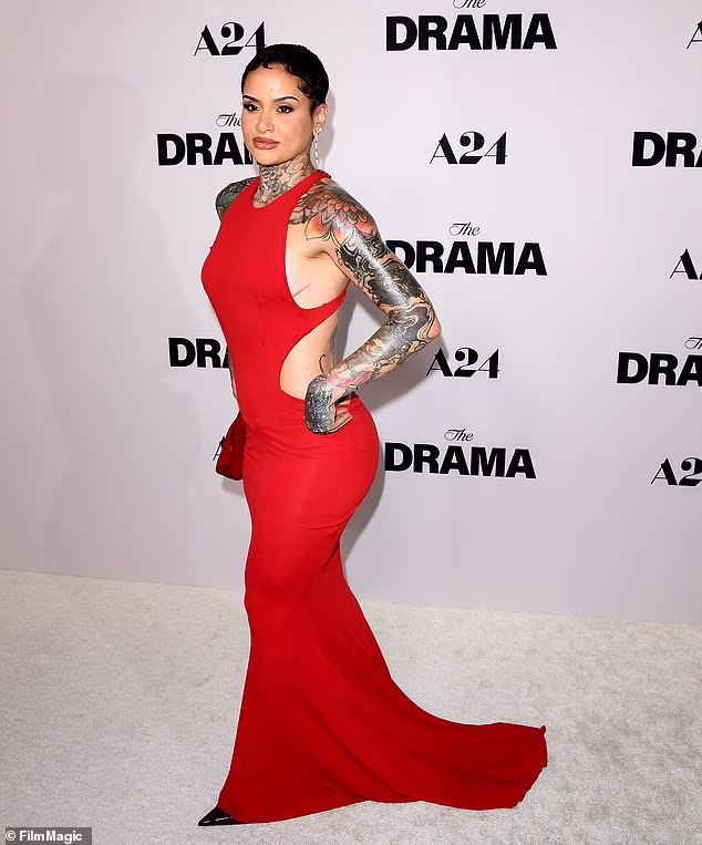 R&B songstress Kehlani - who declared 'F*** ICE' while accepting their two Grammys - showcased her tattooed sleeves in a red cut-out maxi-dress