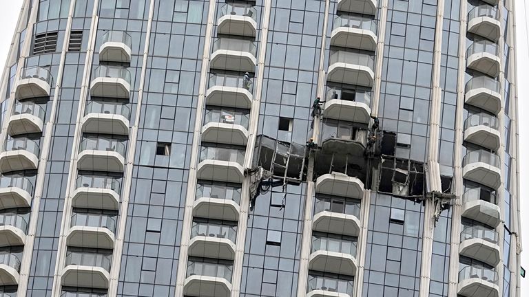 Workers inspect damage caused by a drone strike overnight at the Address Creek Harbour hotel in Dubai. Pic: AP