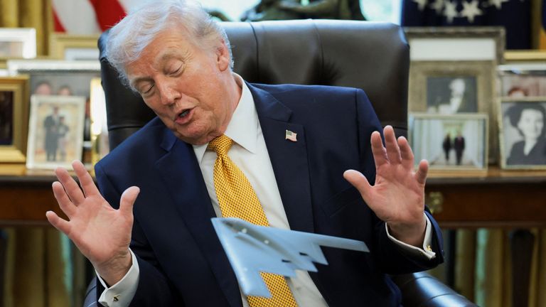 Donald Trump looks at a model aircraft commemorating the US bombing raid against Iran's nuclear facilities. Pic: Reuters