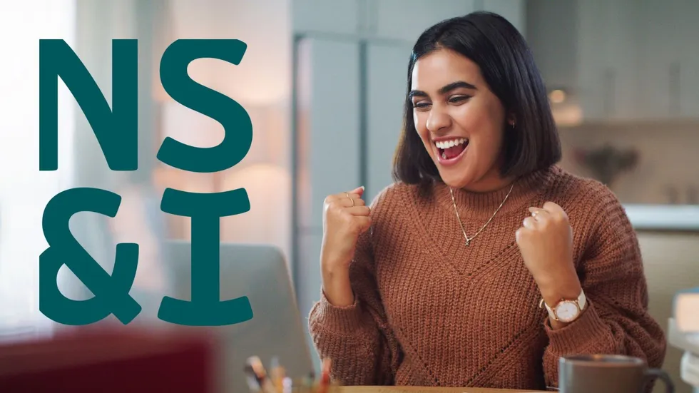 Woman looking happy at laptop and NS&I logo 