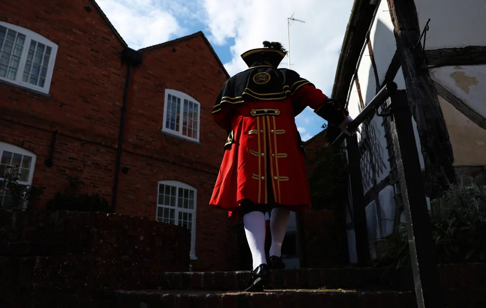 An image of a town crier wearing the red tradition costume