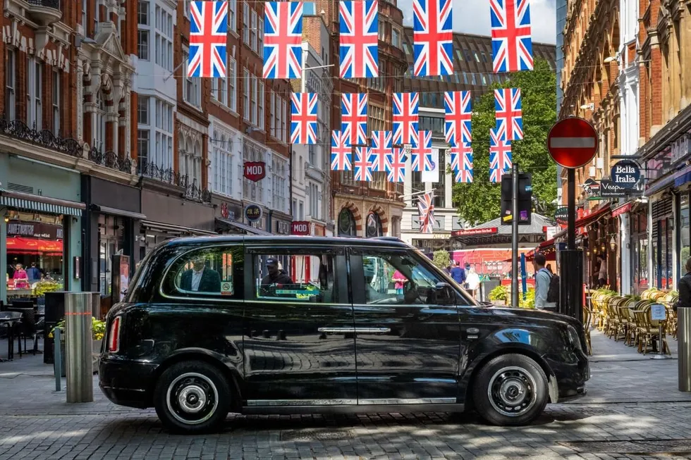 London taxi parked in front of Union Jack flags