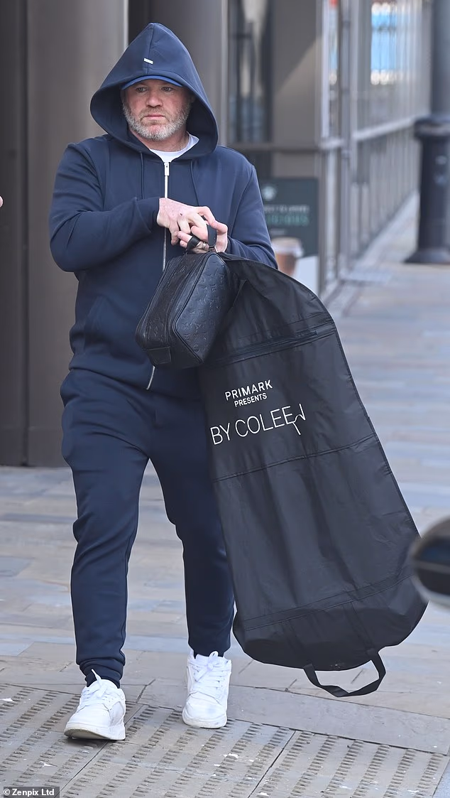 Wayne Rooney gets back in wife Coleen’s good books as he carries his suit in a bag advertising her Primark collection after partying with mystery women
